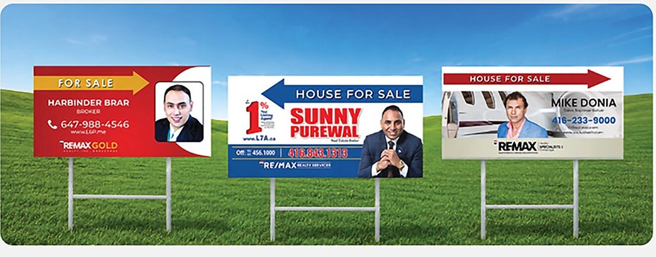 Three double-sided real estate directional signs on H-stakes on a lawn, printed for RE/MAX Gold, RE/MAX Realty Services and RE/MAX Specialists agents