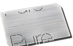 A brushed metal real estate business card with a cut-out logo