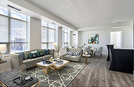 The same living room after virtual staging, furnished with a sofa, armchairs, coffee table and area rug